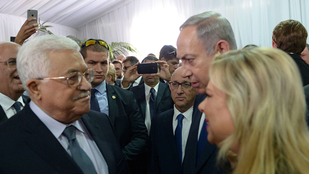 ISRAEL-PERES/ Israeli Prime Minister Benjamin Netanyahu and his wife Sara speak to Palestinian President Mahmoud Abbas (L) during the funeral of former Israeli President Shimon Peres in Jerusalem September 30, 2016. Amos Ben Gershom/Government Press Office (GPO)/Handout via REUTERS ATTENTION EDITORS - THIS IMAGE HAS BEEN SUPPLIED BY A THIRD PARTY. IT IS DISTRIBUTED, EXACTLY AS RECEIVED BY REUTERS, AS A SERVICE TO CLIENTS. FOR EDITORIAL USE ONLY. - RTSQ6QG