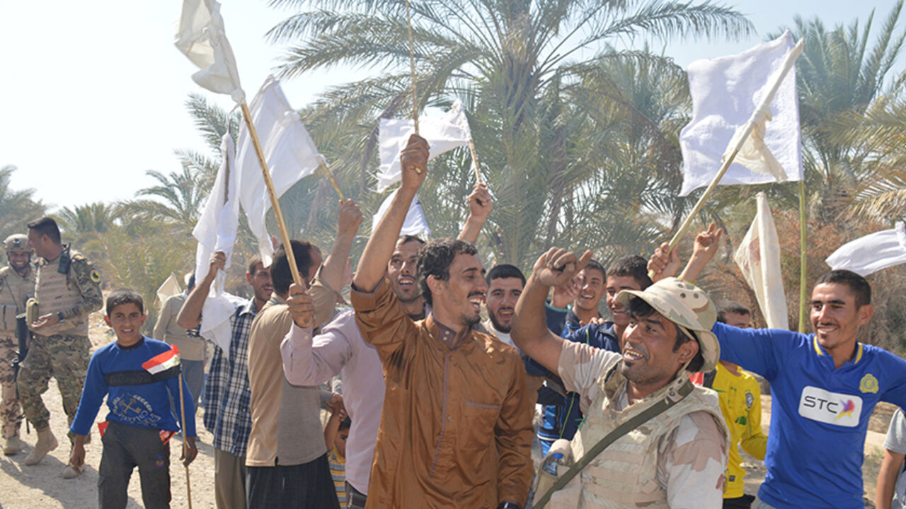 MIDEAST-CRISIS/IRAQ Civilians celebrate with Iraqi army soldiers after returning to their homes in the town of Hit in Anbar province, Iraq October 10, 2016. Picture taken October 10 2016. REUTERS/Stringer - RTSRQ11