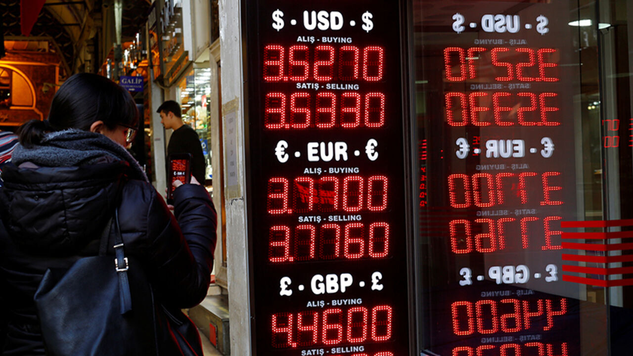 TURKEY-ECONOMY/LIRA-OFFERS A woman uses her mobile phone to take a picture of a display board at a currency exchange office at the Grand Bazaar in Istanbul, Turkey, December 5, 2016. Picture taken December 5, 2016. REUTERS/Murad Sezer - RTSUWLI