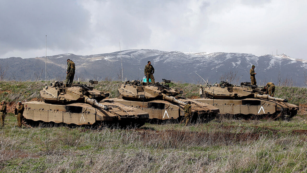 MIDEAST-CRISIS/SYRIA-ISRAEL Israeli soldiers stand atop tanks in the Golan Heights near Israel's border with Syria March 19, 2014. REUTERS/Ronen Zvulun/File Photo - RTX2JLDC