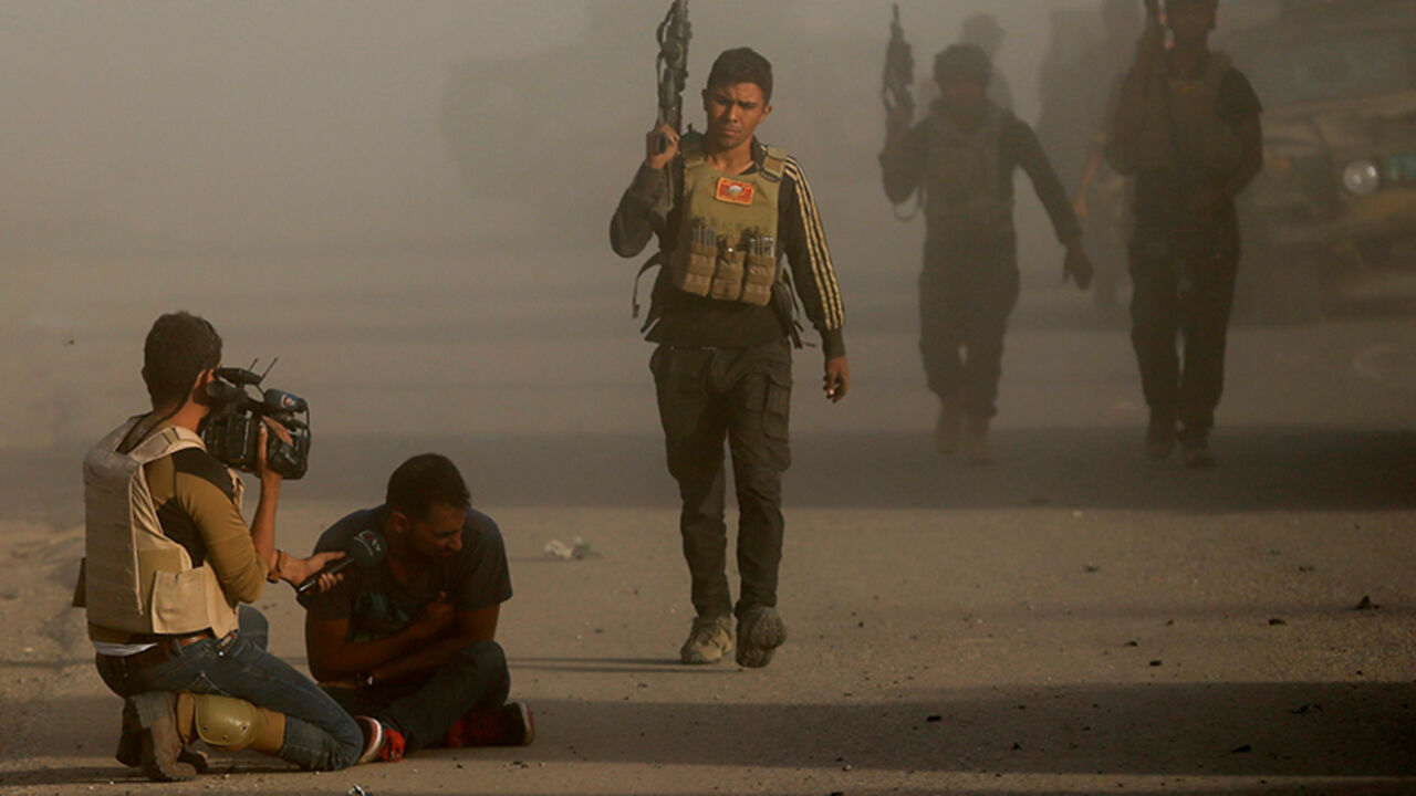 MIDEAST-CRISIS-IRAQ-MOSUL An Iraqi journalist reacts after an Islamic State suicide bomber attacked an Iraqi special forces unit with a car bomb during clashes in Bartella, east of Mosul, Iraq October 20, 2016. REUTERS/Goran Tomasevic - RTX2PQEK