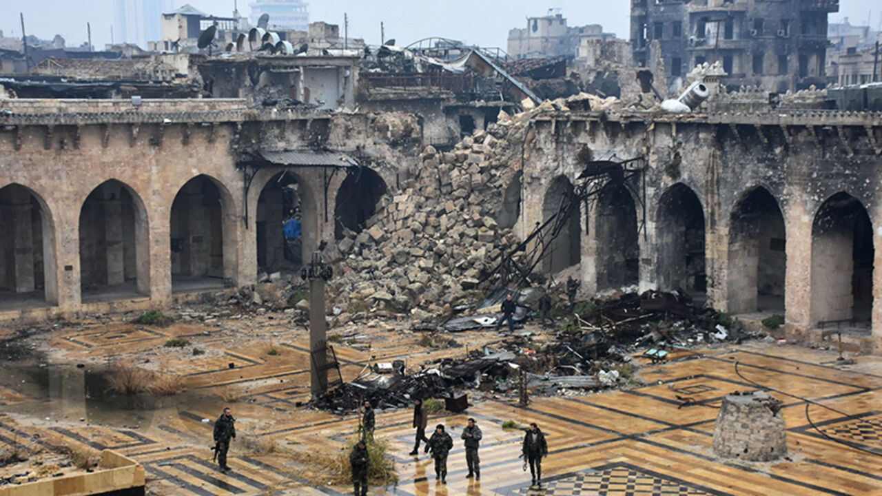AFP_J33UN TOPSHOT - A general view shows Syrian pro-government forces walking in the ancient Umayyad mosque in the old city of Aleppo on December 13, 2016, after they captured the area.
After weeks of heavy fighting, regime forces were poised to take full control of Aleppo, dealing the biggest blow to Syria's rebellion in more than five years of civil war.
/ AFP / George OURFALIAN (Photo credit should read GEORGE OURFALIAN/AFP/Getty Images)