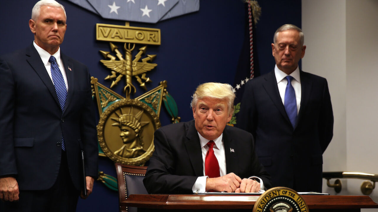 U.S. President Donald Trump signs an executive order to impose tighter vetting of travelers entering the United States, at the Pentagon in Washington, U.S., January 27, 2017. The executive order signed by Trump imposes a four-month travel ban on refugees entering the United States and a 90-day hold on travelers from Syria, Iran and five other Muslim-majority countries. Picture taken January 27, 2017. REUTERS/Carlos Barria - RTSXWM6