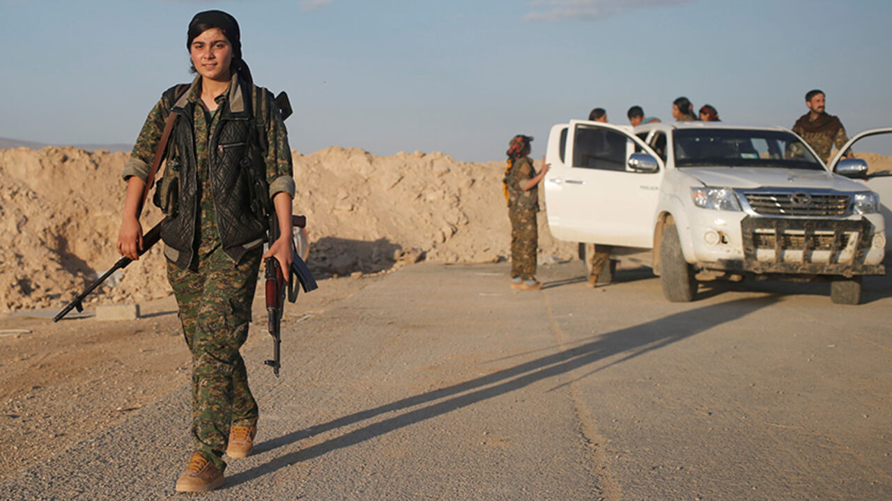 MIDEAST-CRISIS/IRAQ-SINJAR A female member of the Sinjar Resistance Units (YBS), a militia affiliated with the Kurdistan Workers' Party (PKK), carries a sniper and an AK-47 rifle in the village of Umm al-Dhiban, northern Iraq, April 29, 2016. They share little more than an enemy and struggle to communicate on the battlefield, but together two relatively obscure groups have opened up a new front against Islamic State militants in a remote corner of Iraq. The unlikely alliance between the Sinjar Resistance Units, an offshoot of a lefti