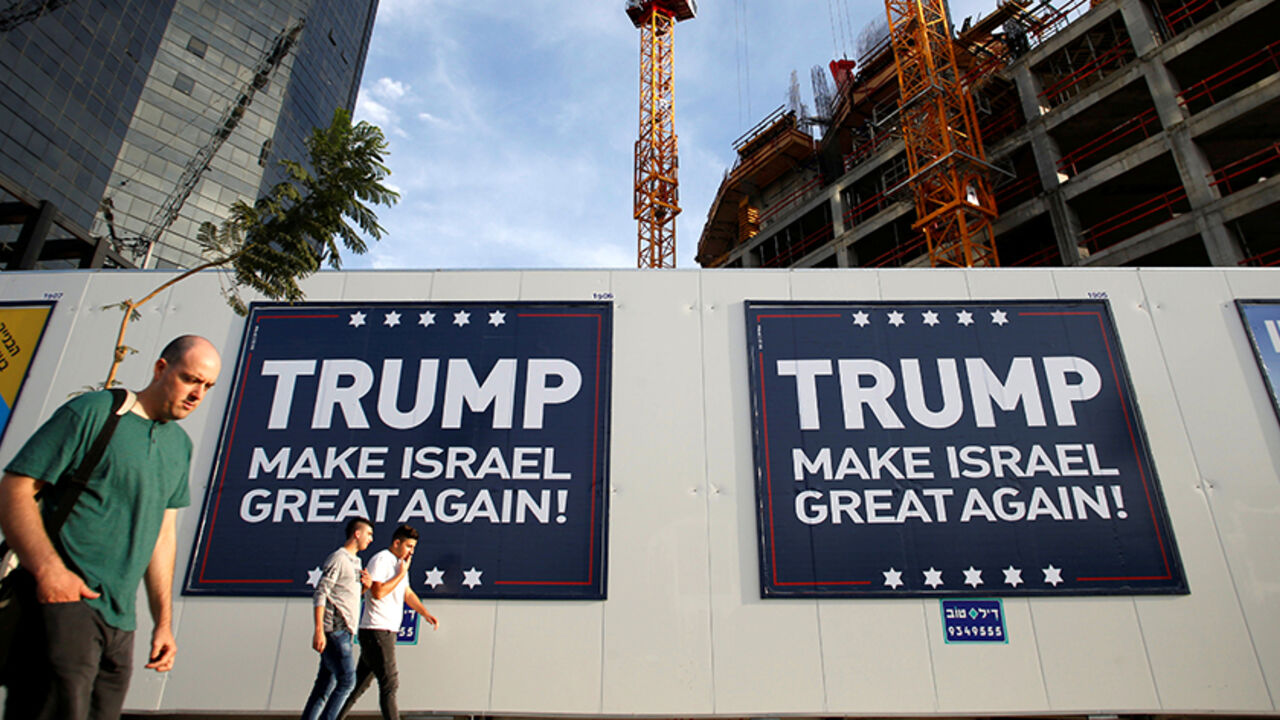 ISRAEL-PALESTINIANS/SETTLEMENTS People walk past signs bearing the name of U.S. President-elect Republican Donald Trump in Tel Aviv, Israel November 14, 2016. REUTERS/Baz Ratner - RTX2TLRV