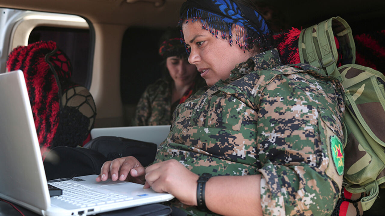 MIDEAST-CRISIS/SYRIA-RAQQA A Kurdish fighter from the People's Protection Units (YPG), operating alongside with the Syrian Democratic Forces (SDF), sits inside a vehicle as she works on a laptop in the town of Hisha after the SDF took control of the area from Islamic State militants, in the northern Raqqa countryside, Syria November 14, 2016. REUTERS/Rodi Said - RTX2TNGJ