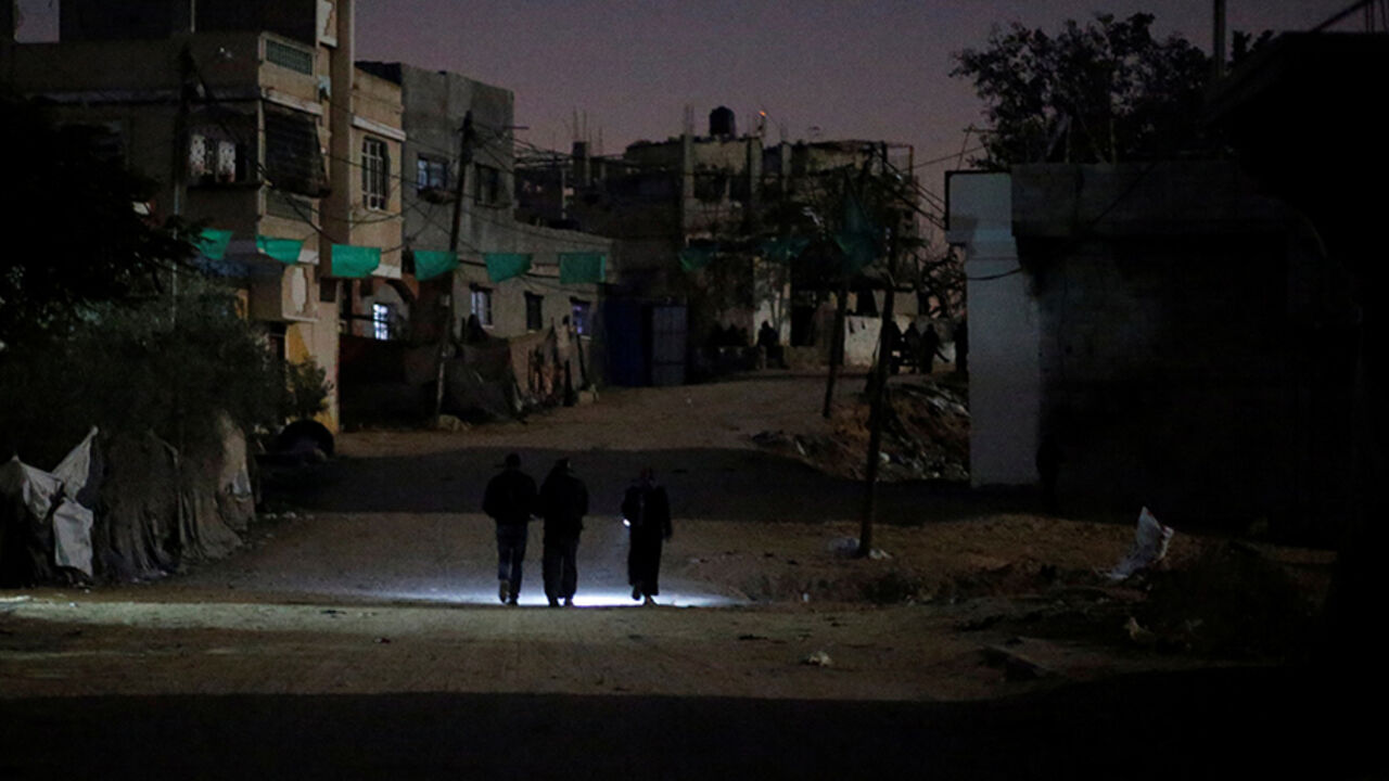 PALESTINIANS-GAZA/ENERGY Palestinians walk on a road during a power cut in Beit Lahiya in the northern Gaza Strip January 11, 2017. Picture taken January 11, 2017. REUTERS/Mohammed Salem - RTX2YNDC