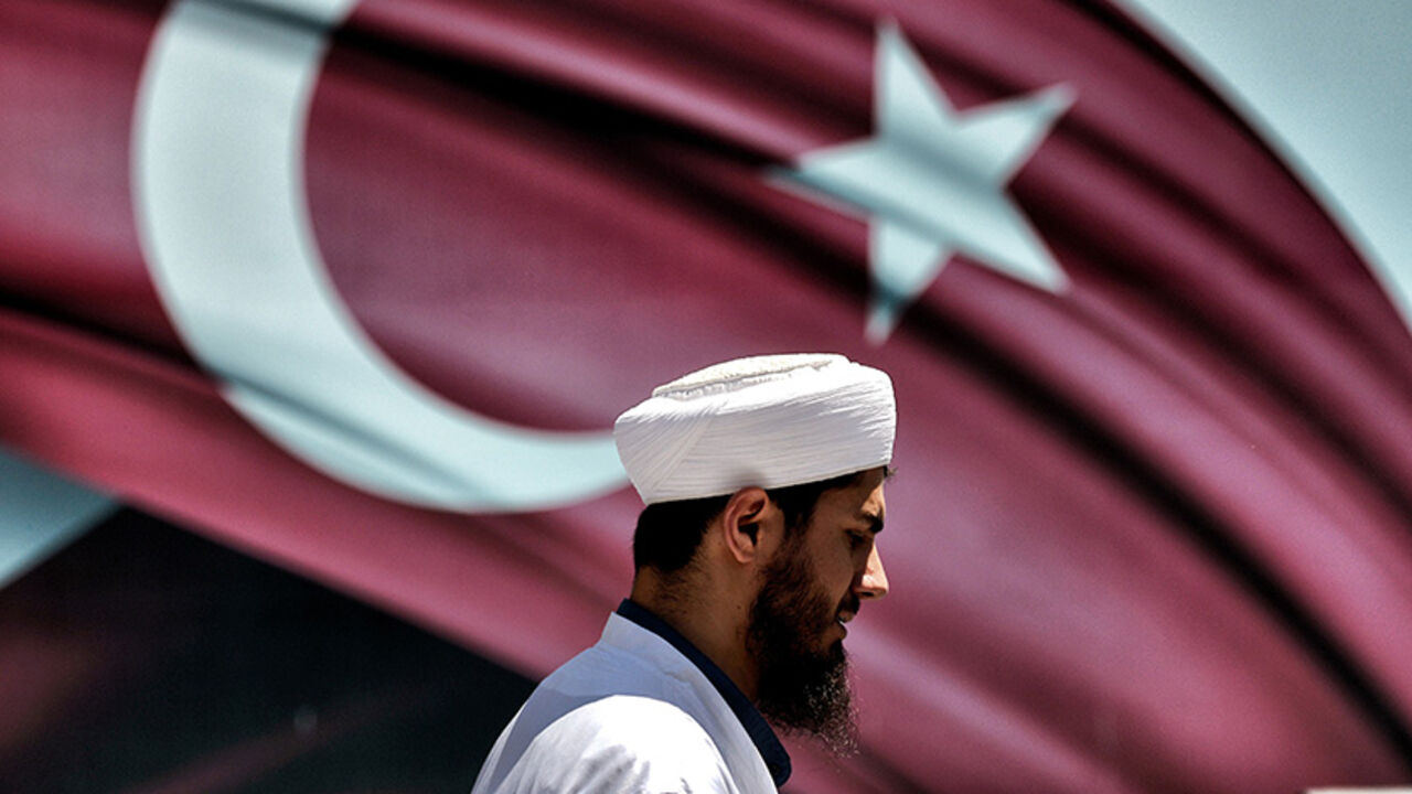 AFP_DD1QK An imam passes the Turkish flag during a demonstration in support of Turkey's President Erdogan (not pictured) at the Sarachane park in Istanbul on July 19, 2016.
Turkey has demanded the resignation of 1,577 university deans suspected of being connected with Friday's attempted coup, state-run news agency Anadolu reported July 19. The country's higher education board made the demand for deans at state and private foundation universities to resign, Anadolu said.
/ AFP / ARIS MESSINIS (Photo credit sh