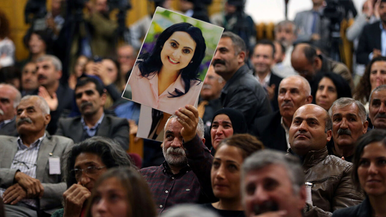 AFP_HV8ZI A supporter holds a portrait of Figen Yuksekdag, detained co-leader of Turkey's pro-Kurdish opposition Peoples' Democratic Party (HDP) at a meeting at the Turkish parliament in Ankara, on November 8, 2016.
The arrest of 10 of the HDP MPs, including party leaders Selahattin Demirtas and Figen Yuksekdag, added to tensions as Turkey wages a relentless battle against Kurdish militants and deals with the aftermath of a July 15 failed coup. / AFP / ADEM ALTAN (Photo credit should read ADEM ALTAN/AFP/Getty