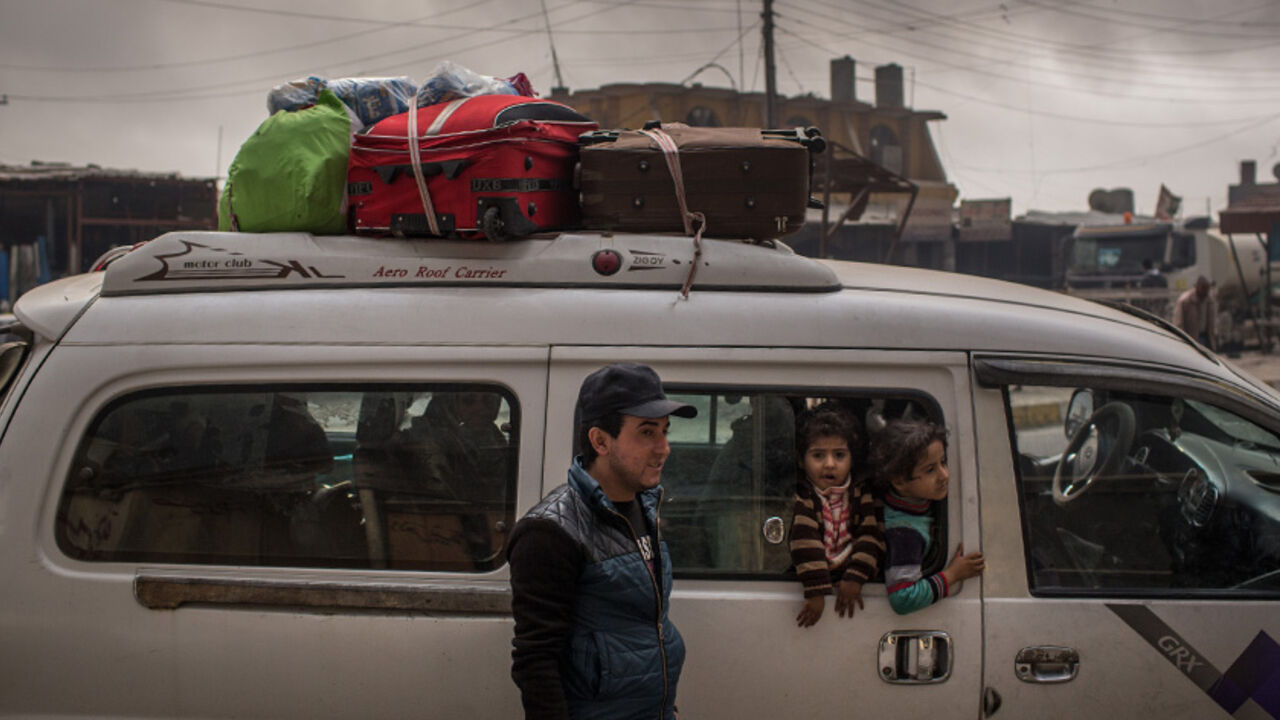 93338891 AL QAYYARAH, IRAQ - NOVEMBER 10: A family returning home waits to pick up supplies from a store under smoke filled skies from burning oil wells set on fire by fleeing ISIS members on November 10, 2016 in Al Qayyarah, Iraq. Many families have begun returning to their homes in recently liberated towns south of Mosul. Oil wells in the area that were set on fire by ISIS continue to burn blanketing the area in think clouds of smoke and oil. (Photo by Chris McGrath/Getty Images)
