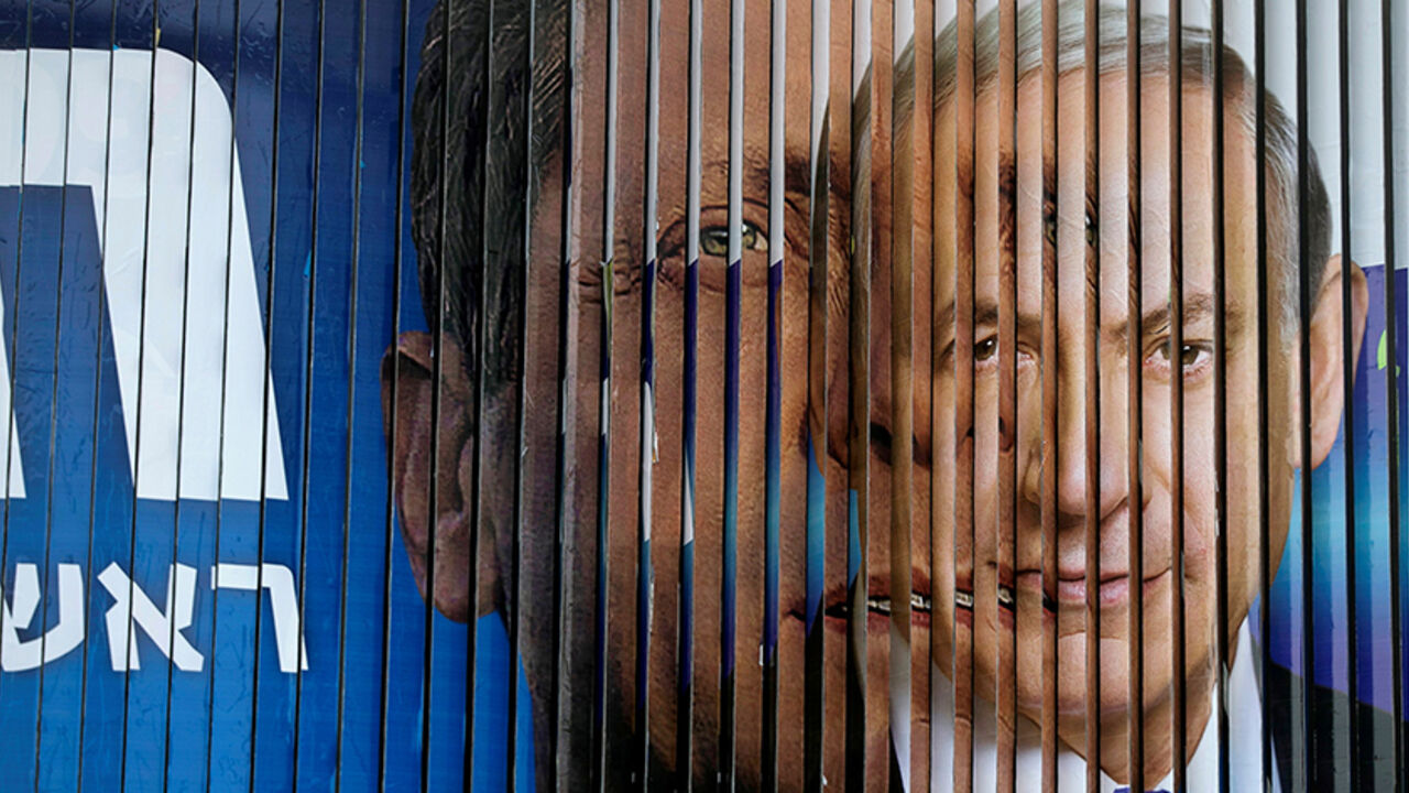 ISRAEL-GOVERNMENT/ Israel's Prime Minister Benjamin Netanyahu (R) and Isaac Herzog, co-leader of the Zionist Union party, are pictured together as campaign billboards rotate in Tel Aviv, March 9, 2015. REUTERS/Baz Ratner/File Photo - RTSEUAF