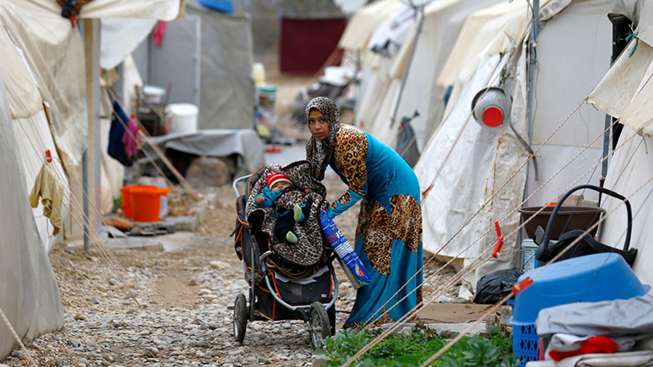 TURKEY-EUROPE/REFUGEES A Syrian refugee mother puts her baby to stroller in Nizip refugee camp, near the Turkish-Syrian border in Gaziantep province, Turkey, November 30, 2016. REUTERS/Umit Bektas - RTSU1P6