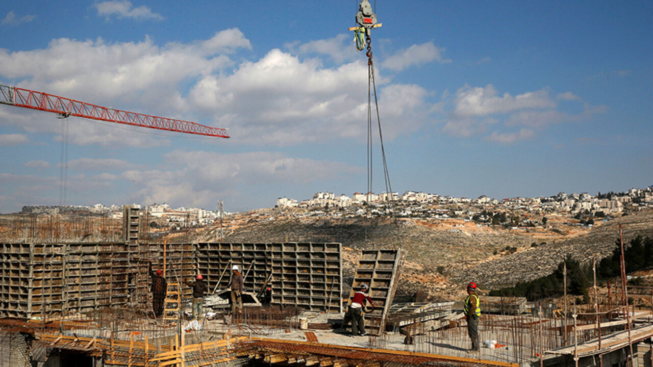 ISRAEL-PALESTINIANS/ Labourers work at a construction site in the Israeli settlement of Ramot in an area of the occupied West Bank that Israel annexed to Jerusalem January 22, 2017. REUTERS/Ronen Zvulun - RTSWSS5