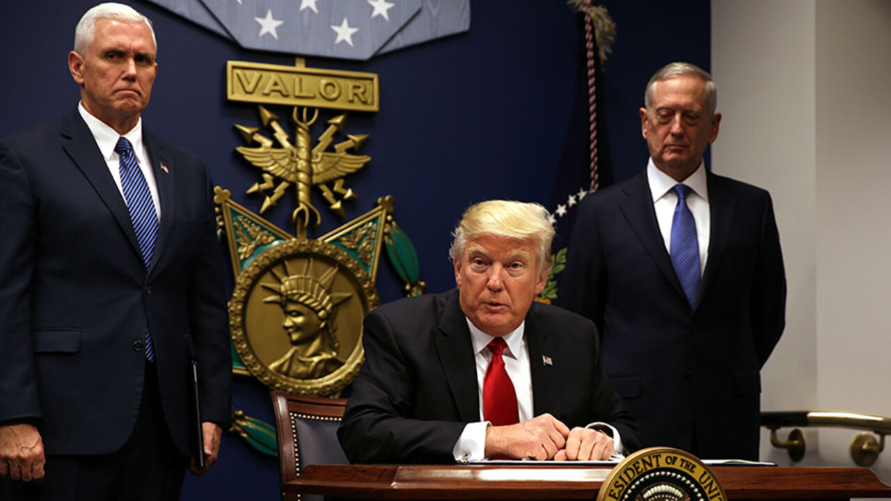 USA-TRUMP/IMMIGRATION U.S. President Donald Trump signs an executive order to impose tighter vetting of travelers entering the United States, at the Pentagon in Washington, U.S., January 27, 2017. The executive order signed by Trump imposes a four-month travel ban on refugees entering the United States and a 90-day hold on travelers from Syria, Iran and five other Muslim-majority countries. Picture taken January 27, 2017. REUTERS/Carlos Barria - RTSXWM6