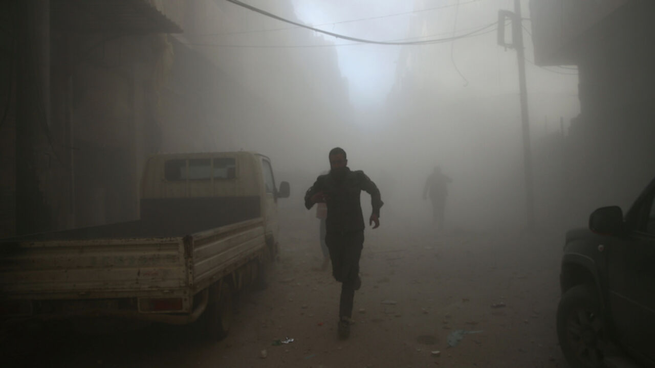 MIDEAST-CRISIS/SYRIA Men run at a site hit by airstrikes in the rebel held besieged Douma neighbourhood of Damascus, Syria February 19, 2017. REUTERS/Bassam Khabieh - RTSZDP3