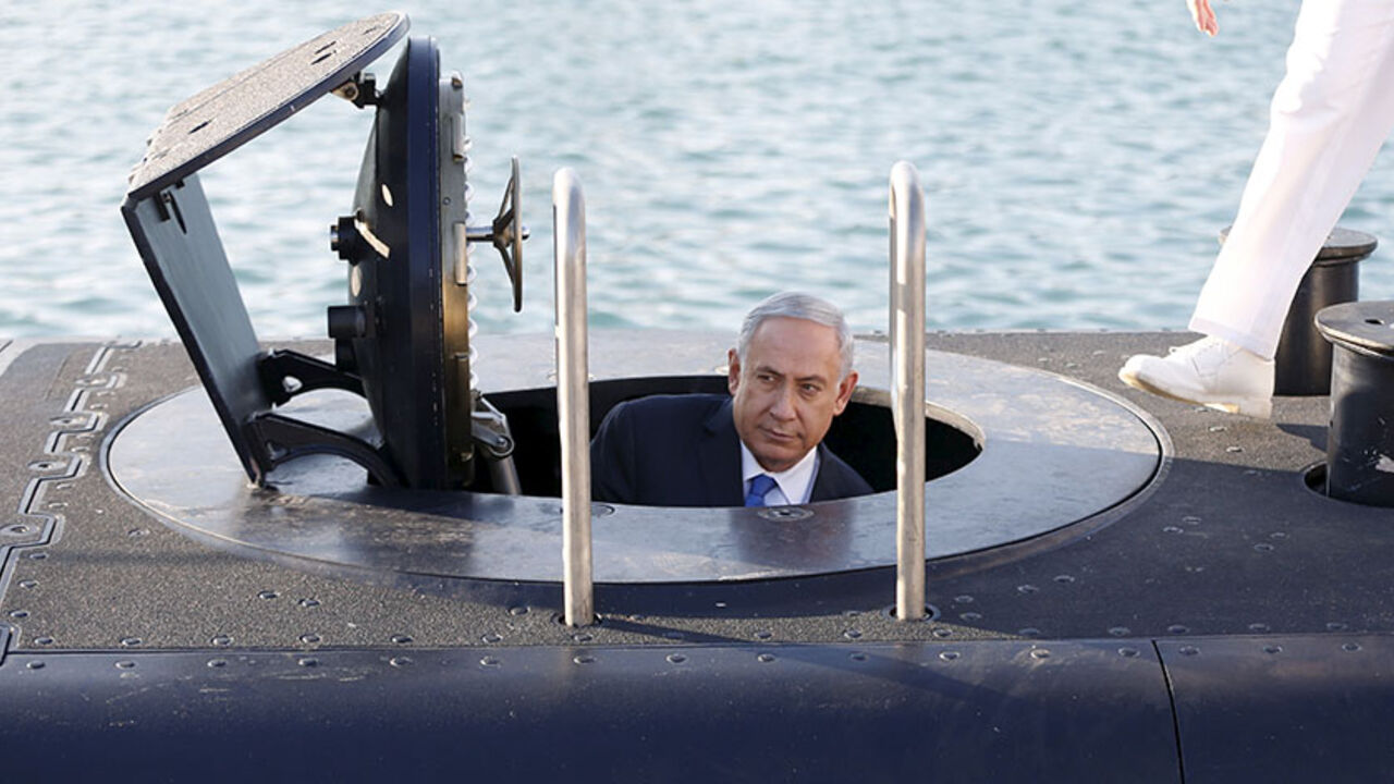 ISRAEL-ARMS/ Israeli Prime Minister Benjamin Netanyahu climbs out after a visit inside the Rahav, the fifth submarine in the fleet, after it arrived in Haifa port January 12, 2016. The Dolphin-class submarines, widely believed to be capable of firing nuclear missiles, were manufactured in Germany and sold to Israel at deep discounts as part of Berlin's commitment to shoring up the security of the country set in part as a haven for Jews who survived the Holocaust.REUTERS/Baz Ratner - RTX221FU