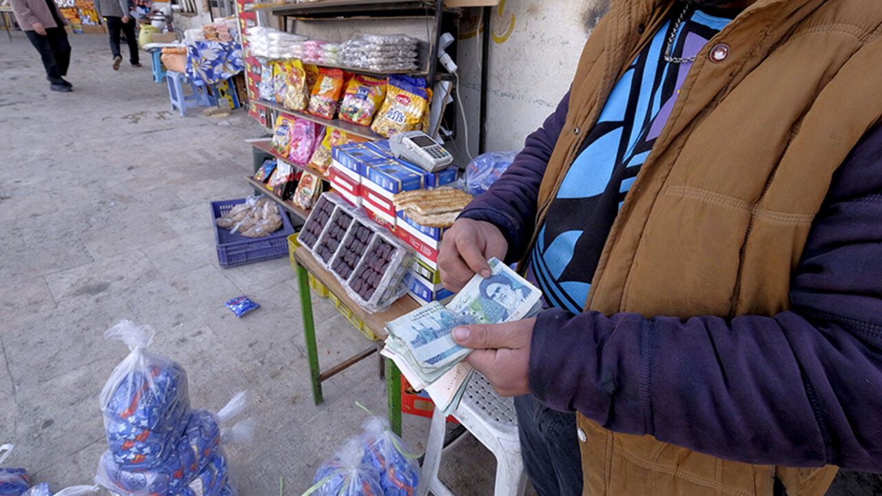 An Iranian shopkeeper counts money as he waits for customers in front of his shop at a bazar in northern Tehran January 16, 2016. REUTERS/Raheb Homavandi/TIMA  ATTENTION EDITORS - THIS IMAGE WAS PROVIDED BY A THIRD PARTY. FOR EDITORIAL USE ONLY.  - RTX22MU3