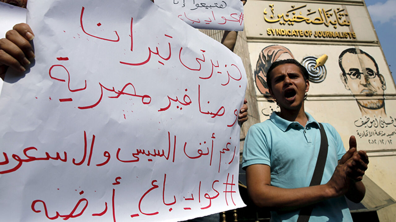 EGYPT-SISI/ Egyptian activists shout anti-President Abdel Fattah al-Sisi and government slogans during a demonstration protesting against the government's decision to transfer two Red Sea islands to Saudi Arabia, in front of the Press Syndicate in Cairo, Egypt, April 13, 2016. The sign reads, "The two Islands Tiran and Sanafir are the Egyptians". REUTERS/Amr Abdallah Dalsh - RTX29RVO