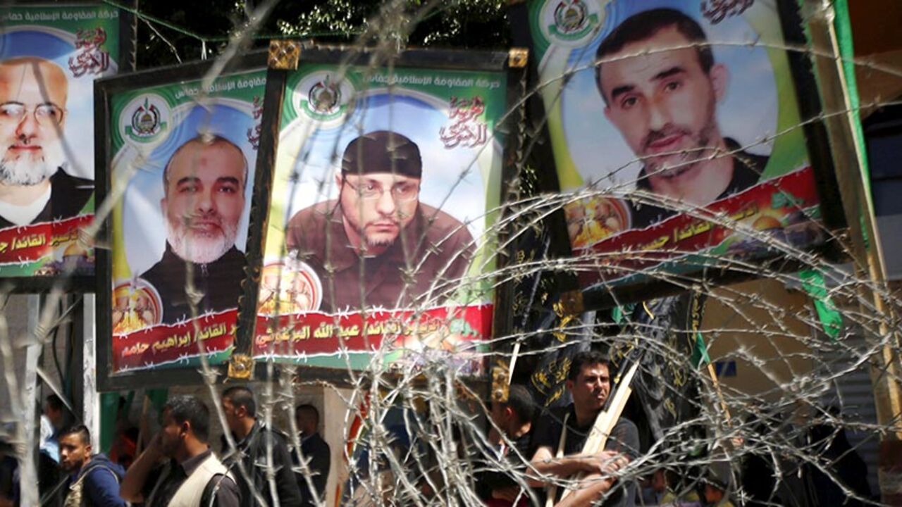 ISRAEL-PALESTINIANS/ Pictures of Palestinian Hamas militants held in Israeli jails are seen through a fence during a rally marking Palestinian Prisoner Day, in Gaza City April 17, 2016. REUTERS/Mohammed Salem - RTX2AAQR