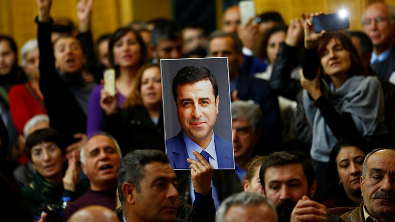 TURKEY-SECURITY/EU A supporter holds a portrait of Selahattin Demirtas, detained leader of Turkey's pro-Kurdish opposition Peoples' Democratic Party (HDP) at a meeting at the Turkish parliament in Ankara, Turkey, November 8, 2016, in the absence of Demirtas and other HDP lawmakers who were jailed after refusing to give testimony in a probe linked to "terrorist propaganda". REUTERS/Umit Bektas - RTX2SH5T