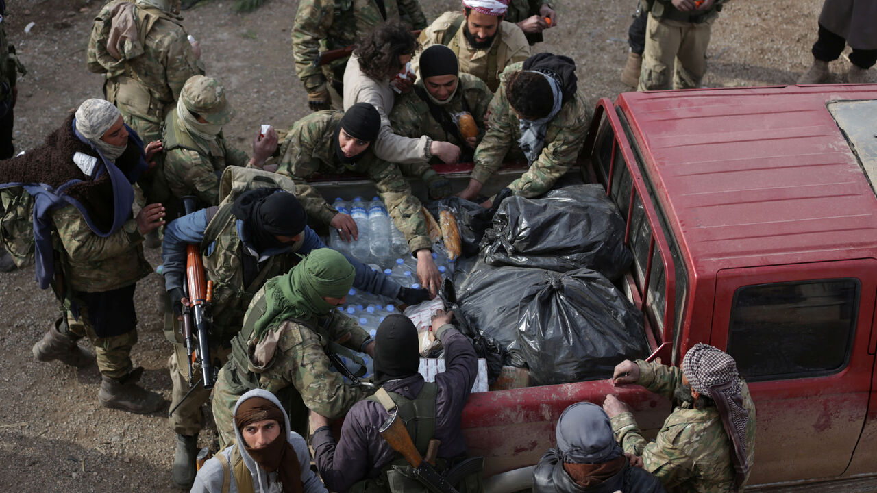 MIDEAST-CRISIS-SYRIA-ALBAB Rebel fighters gather around a pick-up truck carrying food on the outskirts of the northern Syrian town of al-Bab, Syria February 8, 2017. REUTERS/Khalil Ashawi - RTX306A0