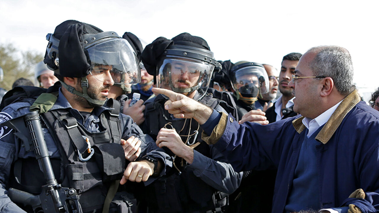 AFP_K36FT TOPSHOT - Arab-Israeli Knesset (Israel's Parliament) members, Ahmad al-Tibi (R) confronts an Israeli policeman during clashes with Bedouin protesters in the village of Umm al-Hiran, which is not recognized by the Israeli government, near the southern city of Beersheba, in the Negev desert, on January 18, 2017.
An Israeli policeman was killed while taking part in an operation to demolish homes in the Bedouin village, with authorities claiming he was targeted in a car-ramming attack. The driver was earlier r