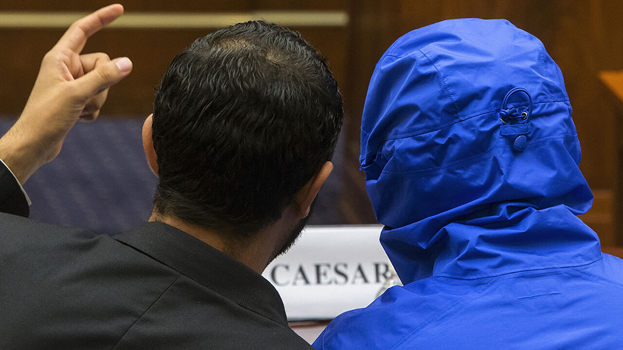 USA-SYRIA/ The man credited with smuggling 50,000 photos said to document Syrian government atrocities, a Syrian Army defector known by the protective alias Caesar (disguised in a hooded blue jacket), listens to his interpreter as he prepares to speak at a briefing to the House Foreign Affairs Committee on Capitol Hill in Washington July 31, 2014. REUTERS/Jonathan Ernst (UNITED STATES - Tags: POLITICS MILITARY) - RTR40T3S