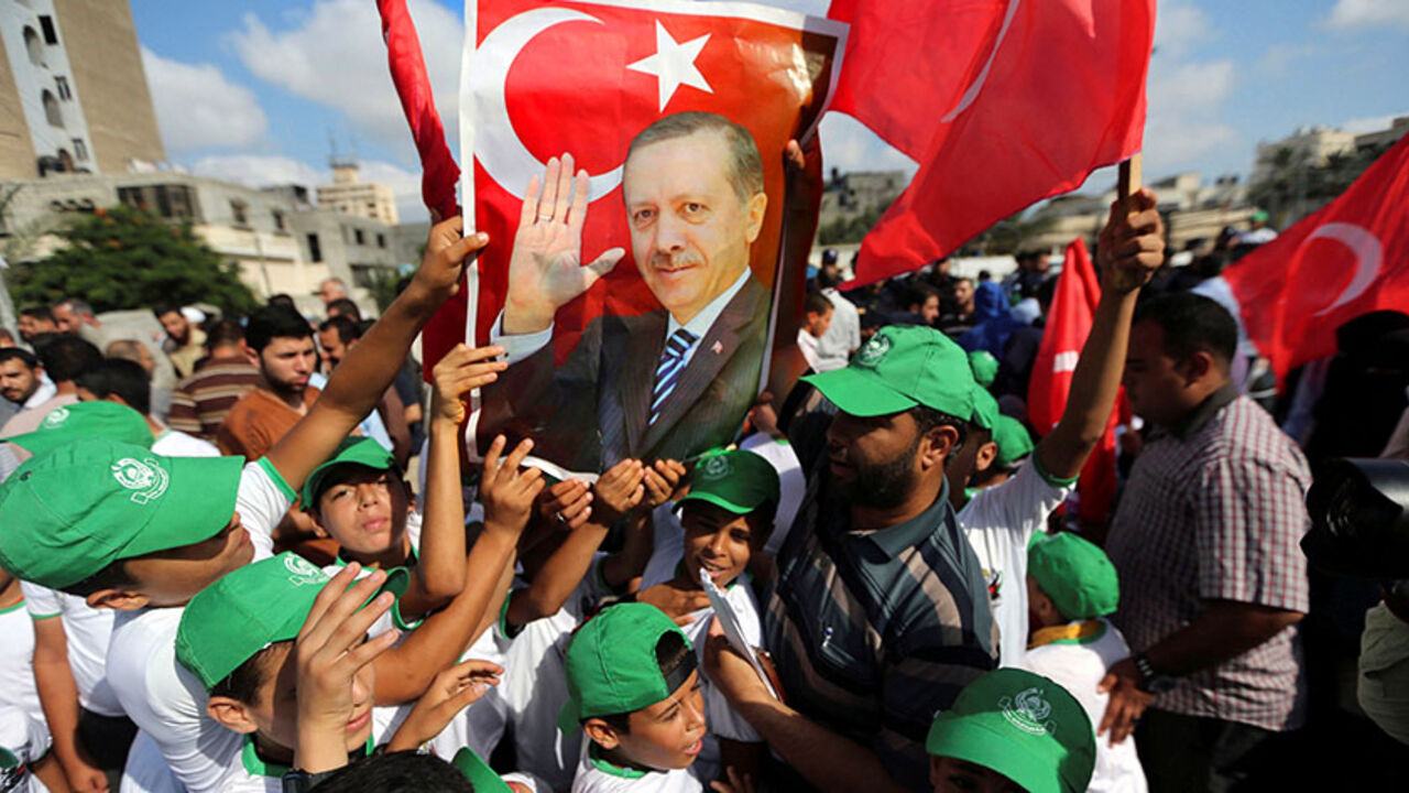 TURKEY-SECURITY/REACTION Palestinians hold a poster of Turkish President Tayyip Erdogan during a Hamas rally in support of Erdogan's government against a coup attempt, in Khan Younis in the southern Gaza Strip July 16, 2016. REUTERS/Ibraheem Abu Mustafa TPX IMAGES OF THE DAY - RTSI917