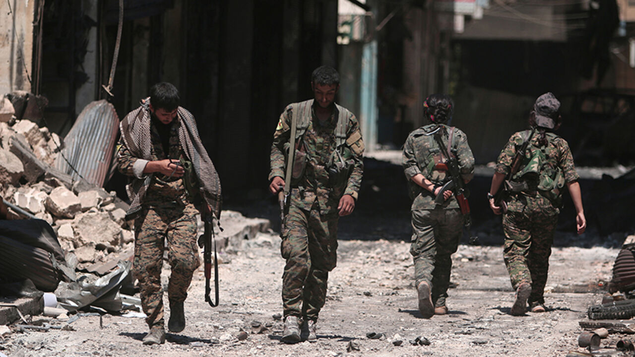 MIDEAST-CRISIS/MANBIJ Syria Democratic Forces (SDF) fighters walk on the rubble of damaged shops and buildings in the city of Manbij, in Aleppo Governorate, Syria, August 10, 2016. REUTERS/Rodi Said - RTSMDAF
