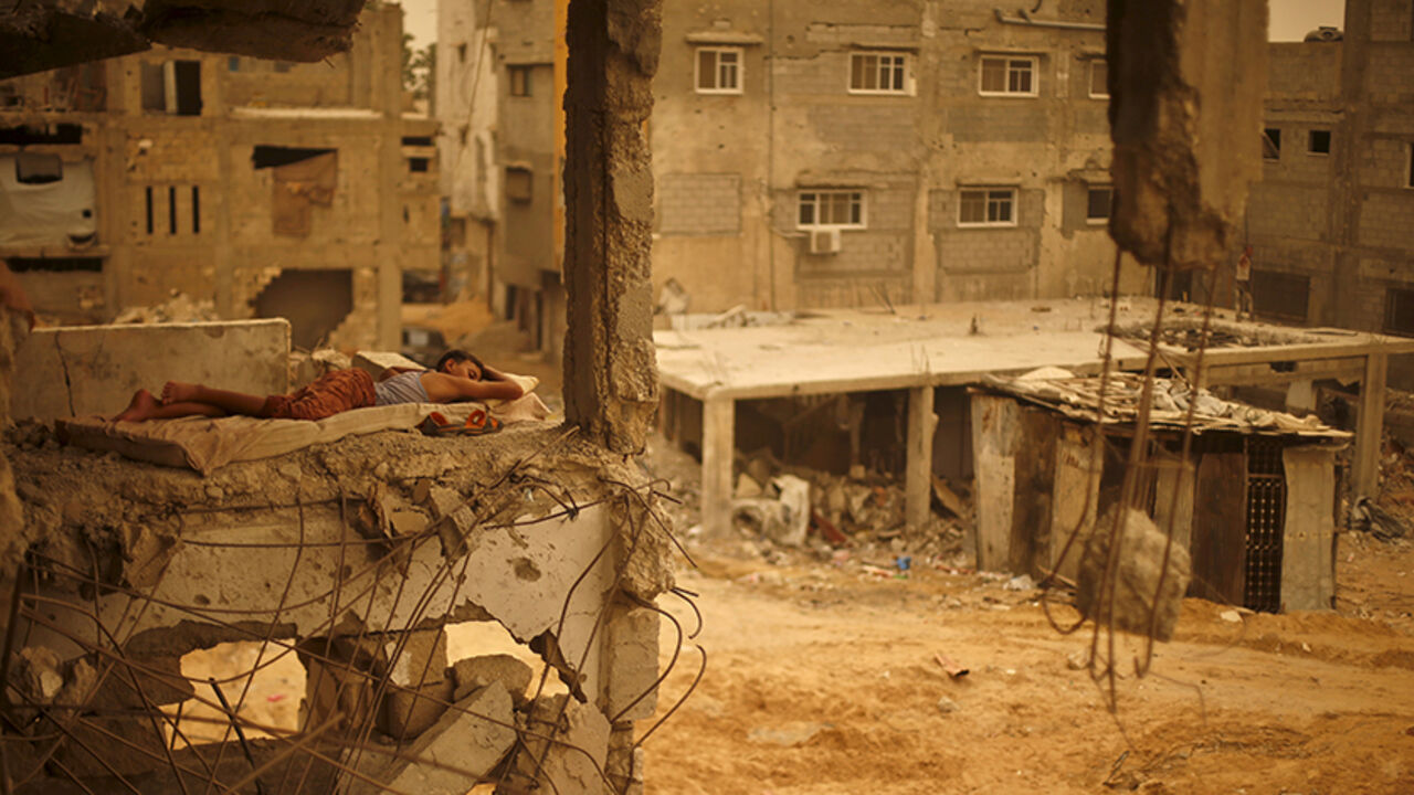 MIDEAST-STORM/ A Palestinian boy sleeps on a mattress inside the remains of his family's house, which witnesses said was destroyed by Israeli shelling during a 50-day war in 2014 summer, during a sandstorm in Gaza September 8, 2015. A heavy sandstorm swept across parts of the Middle East on Tuesday, killing two people and hospitalising hundreds in Lebanon and disrupting fighting and air strikes in neighboring Syria. Clouds of dust also engulfed Israel, Jordan and Cyprus where aircraft were diverted to Paphos from Larnaca
