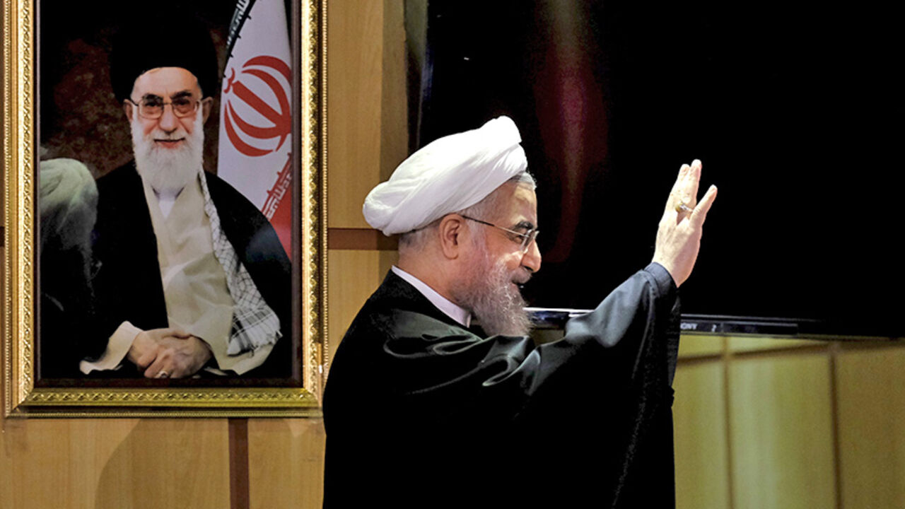 IRAN-ELECTION/ Iranian President Hassan Rouhani waves as he stands next to a portrait of Iran's Supreme Leader Ayatollah Ali Khamenei, after he registered for February's election of the Assembly of Experts, the clerical body that chooses the supreme leader, at Interior Ministry in Tehran December 21, 2015. REUTERS/Raheb Homavandi/TIMA ATTENTION EDITORS - THIS IMAGE WAS PROVIDED BY A THIRD PARTY. FOR EDITORIAL USE ONLY. TPX IMAGES OF THE DAY - RTX1ZKHQ