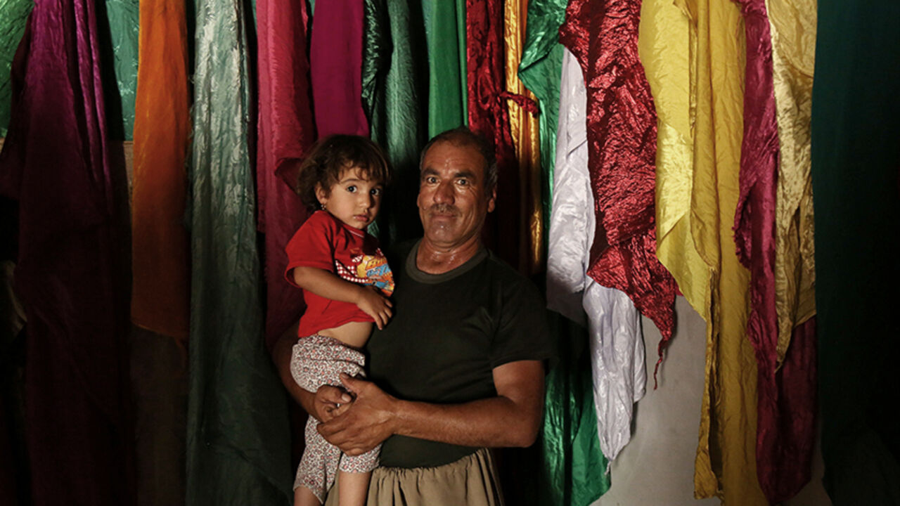 MIDEAST-CRISIS/IRAQ A Yazidi man carries his child at the Sharaf Al-Deen temple in Shingal's outskirts, Iraq, August 14, 2016. REUTERS/Ari Jalal - RTX2KT69