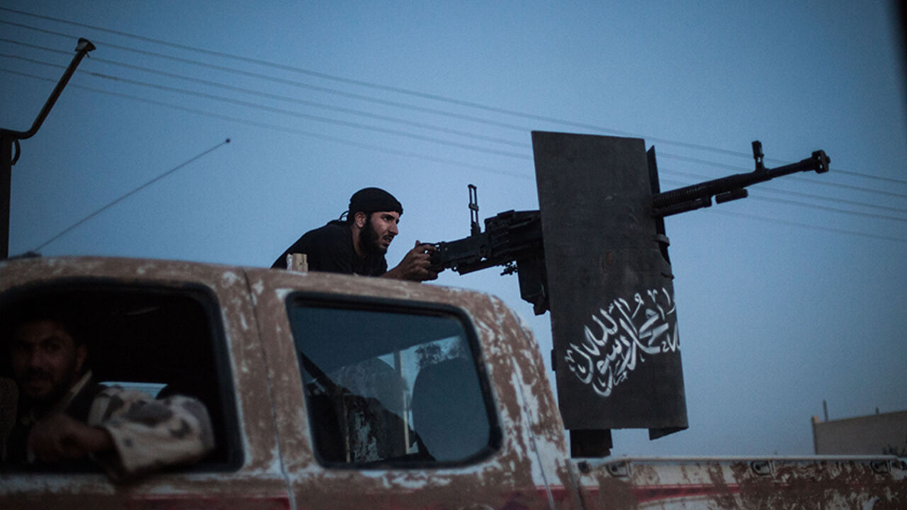 A member of the  Islamist Syrian opposition group Ahrar al-Sham fires against a position of the Committees for the Protection of the Kurdish People (YPG), a militia set up to protect Kurdish areas in Syria from opposing forces, during clashes in the countryside of the northern Syrian Raqqa province on August 25, 2013. Syrian Foreign Minister Walid Muallem said on August 27 the UN mission investigating alleged chemical weapons attacks in Damascus has been delayed until the following after rebels failed to gu