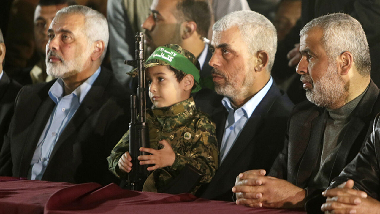 AFP_N163L TOPSHOT - Yahya Sinwar (2nd R), the new leader of the Hamas Islamist movement in the Gaza Strip and senior political leader Ismail Haniyeh (L) sit next to the son of Mazen Faqha, a Hamas leader who was shot dead by unknown gunmen in the Gaza Strip, during a memorial on March 27, 2017 in Gaza City.
Hamas officials have said the killing bears the hallmarks of Israel's intelligence service Mossad, but Israel has not commented on the shooting. / AFP PHOTO / MAHMUD HAMS (Photo credit should read MAHMUD