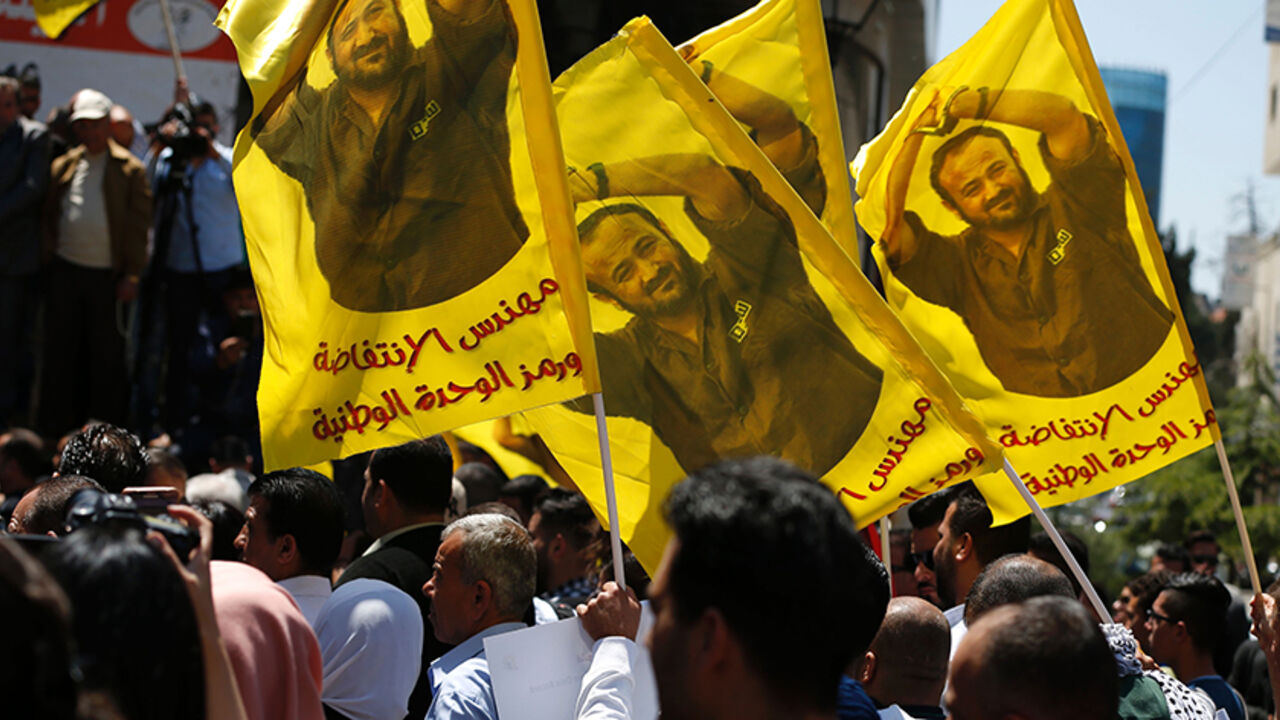 AFP_NM344 Protesters wave flags bearing a portrait of prominent jailed Palestinian Marwan Barghouti during a rally in the West Bank city of Ramallah to show their support to Palestinians detained in Israeli jails after hundred of them launched a hunger strike on April 17, 2017.
More than 1,000 Palestinians in Israeli jails launched a hunger strike following a call from Barghouti, a Palestinian Authority official said. / AFP PHOTO / ABBAS MOMANI (Photo credit should read ABBAS MOMANI/AFP/Getty Images)
