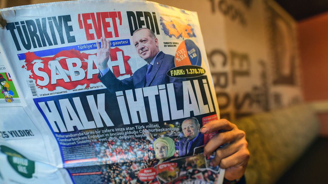 AFP_NM3J5 A man reads Sabah newspaper bearing a headline which translates as "Revolution of people"" in Istanbul on April 17, 2017, a day after Turkey's referendum.
The deputy leader of Turkey's opposition Republican People's Party (CHP) called on April 17, 2017 for the results of a referendum agreeing new powers for President Recep Tayyip Erdogan to be annulled. / AFP PHOTO / YASIN AKGUL (Photo credit should read YASIN AKGUL/AFP/Getty Images)