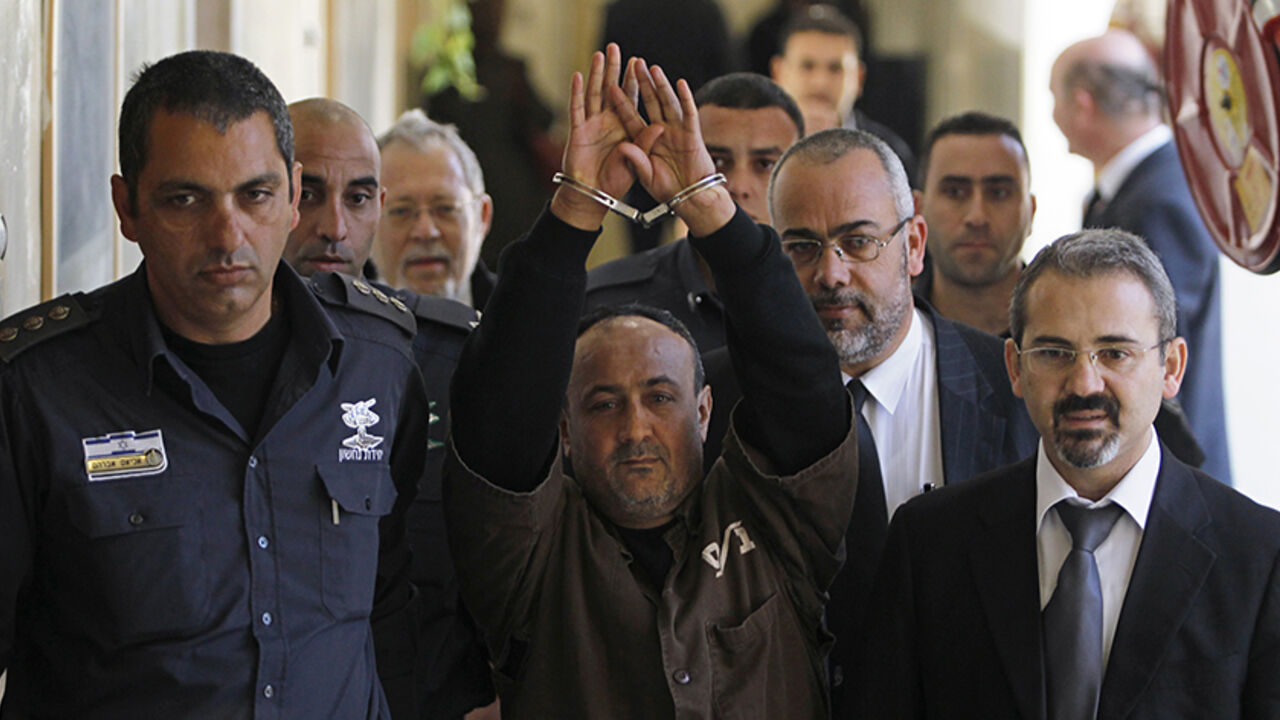 PALESTINIANS-ISRAEL/ An Israeli prison guard escorts jailed Fatah leader Marwan Barghouti (C) to a deliberation at Jerusalem Magistrate's court January 25, 2012. Convicted of murder for his role in attacks on Israelis, Barghouti was jailed for life by Israel in 2004.
REUTERS/Baz Ratner (JERUSALEM - Tags: POLITICS CRIME LAW) - RTR2WTIC