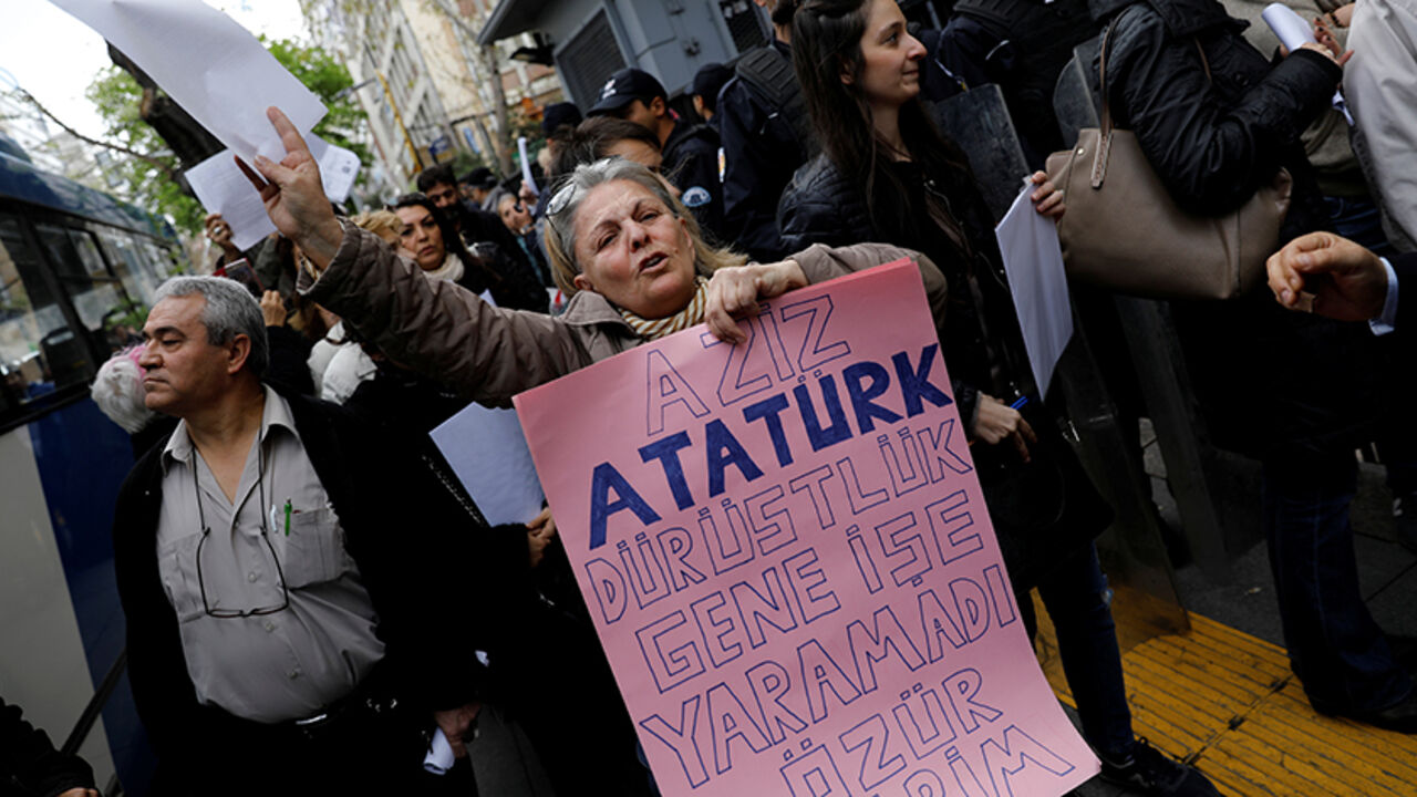 TURKEY-POLITICS/ A woman holds a banner reads, "Dear Ataturk; honesty didn't work again. I am sorry" as she and other people wait in line to submit their personal appeals to the High Electoral Board for annulment of the referendum, in Ankara, Turkey, April 18, 2017. REUTERS/Umit Bektas - RTS12RUF