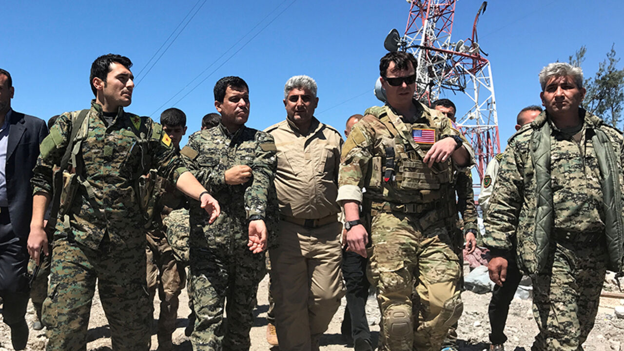 MIDEAST-CRISIS/TURKEY-IRAQ A U.S. military commander (2nd R) walks with Kurdish fighters from the People's Protection Units (YPG) at the YPG headquarters that was hit by Turkish airstrikes in Mount Karachok near Malikiya, Syria April 25, 2017. REUTERS/Rodi Said - RTS13T7Q