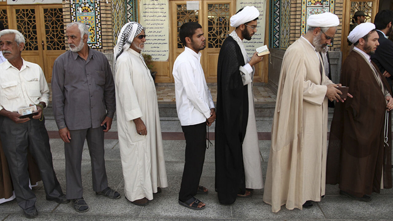 IRAN-ELECTION/ Men stand in line to vote during the Iranian presidential election at a mosque in Qom, 120 km (74.6 miles) south of Tehran June 14, 2013. Millions of Iranians voted to choose a new president on Friday, urged by Supreme Leader Ayatollah Ali Khamenei to turn out in force to discredit suggestions by arch foe the United States that the election would be unfair. REUTERS/Fars News/Mohammad Akhlagi (IRAN - Tags: POLITICS ELECTIONS) ATTENTION EDITORS - THIS IMAGE WAS PROVIDED BY A THIRD PARTY. FOR EDITORIAL USE ON