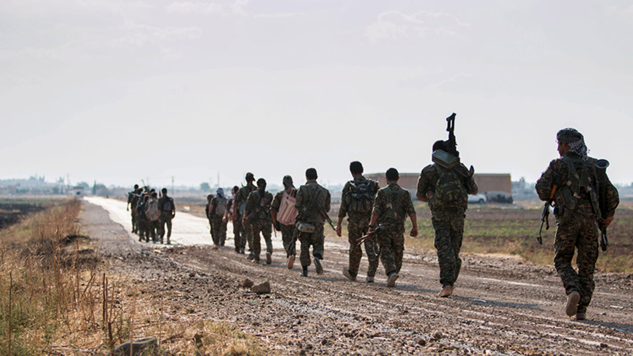 MIDEAST-CRISIS/KURDS Kurdish fighters walk carrying their weapons towards Tel Abyad of Raqqa governorate after they said they took control of the area June 15, 2015. Syrian Kurdish-led forces said they had captured a town at the Turkish border from Islamic State on Monday, driving it away from the frontier in an advance backed by U.S.-led air strikes that has thrust deep into the jihadists' Syria stronghold. The capture of Tel Abyad by the Kurdish YPG and smaller Syrian rebel groups means the Syrian Kurds effectively control so