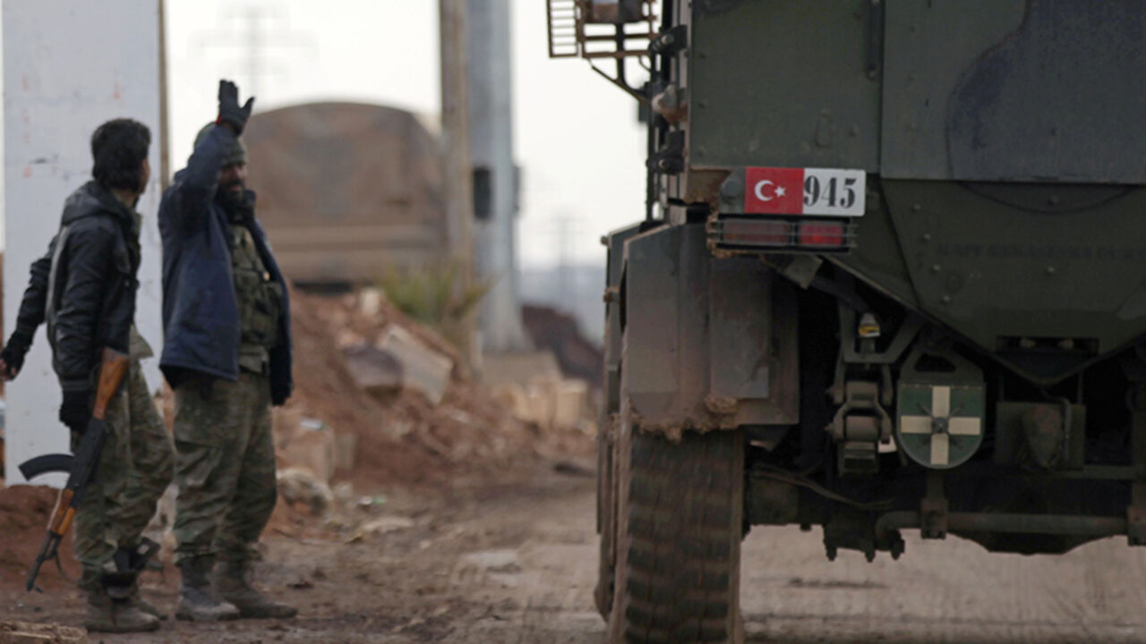 MIDEAST-CRISIS/SYRIA-TURKEY Free Syrian Army fighters gesture as Turkish military vehicles drive in the Syrian rebel-held town of al-Rai while heading towards the northern Syrian town of al-Bab, Syria January 9, 2017. REUTERS/Khalil Ashawi - RTX2Y605
