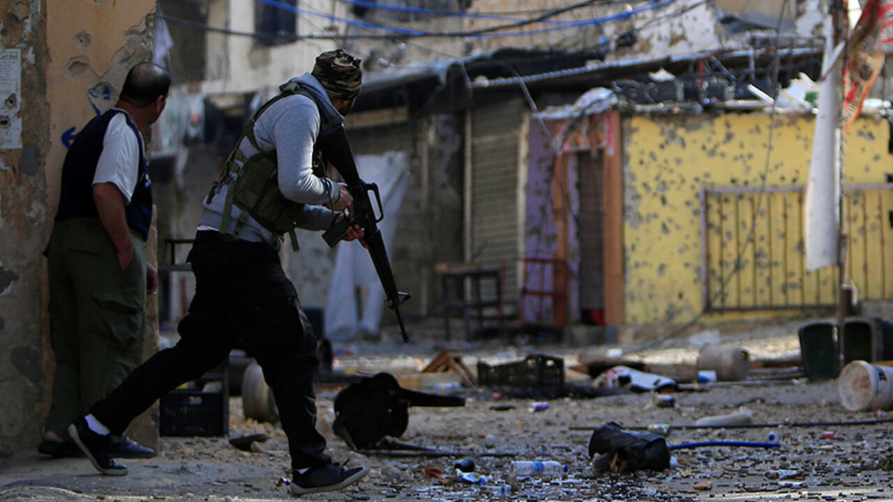 LEBANON-SECURITY/ A Palestinian Fatah gunman carries his weapon and he attempts to cross a street at the Ain el-Hilweh refugee camp near Sidon, southern Lebanon April 10, 2017. REUTERS/Ali Hashisho TPX IMAGES OF THE DAY - RTX34VZC
