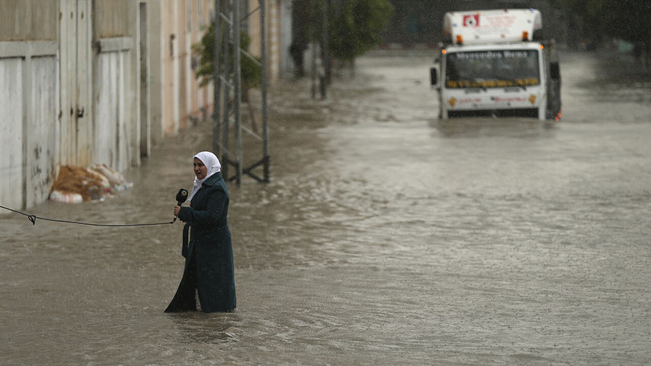 MIDEAST-PALESTINIANS/ A Palestinian journalist speaks to the camera as she stands on a flooded street following heavy rain in Gaza City November 27, 2014. The civil defence asked residents in an area east of Gaza City to evacuate their homes to avoid being trapped in flood waters from a nearby lake. REUTERS/Mohammed Salem (GAZA - Tags: SOCIETY ENVIRONMENT MEDIA TPX IMAGES OF THE DAY) - RTR4FST8