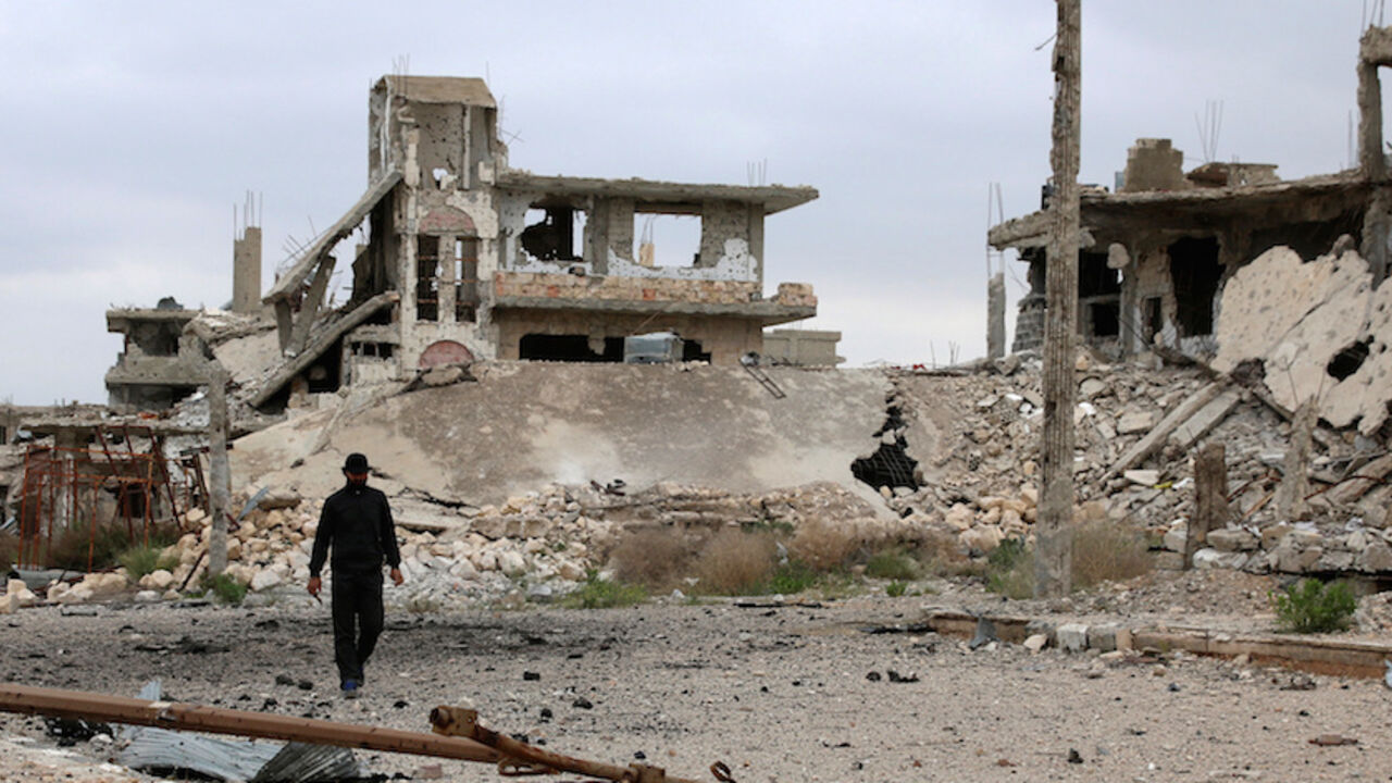MIDEAST-CRISIS/SYRIA A man walks past damaged buildings in rebel-held area of southern city of Deraa, Syria April 23, 2017. REUTERS/Alaa Al-Faqir - RTS13IWY