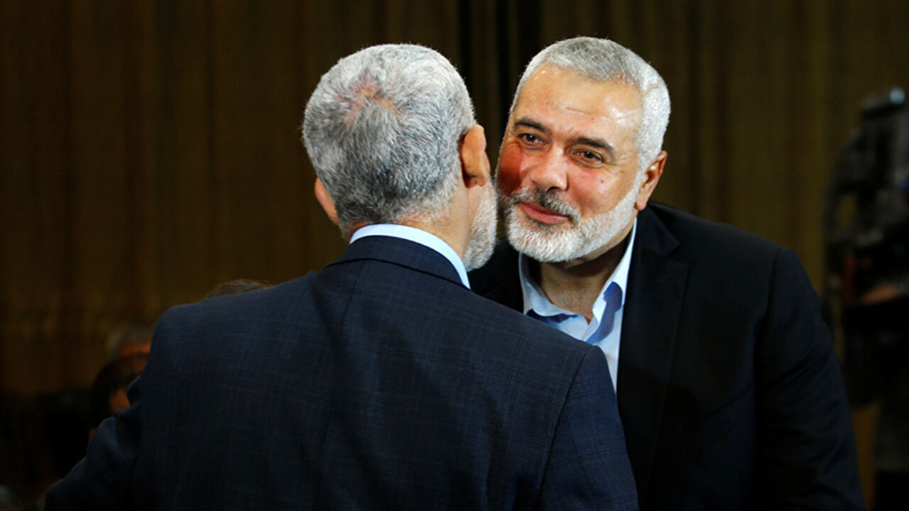 PALESTINIANS-HAMAS/DOCUMENT-MESHAAL Hamas leader Ismail Haniyeh (R) kisses Hamas Gaza Chief Yehya Al-Sinwar during a ceremony announcing a new policy document, in Gaza City May 1, 2017. REUTERS/Mohammed Salem - RTS14OXA