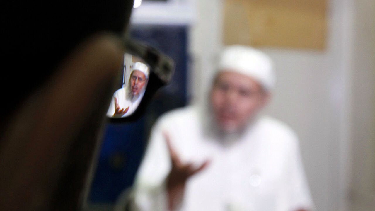 EGYPT-PROTESTS/ISLAMISTS Abdel Akhir Hammad, spiritual leader of the formerly militant group al-Gamaa al-Islamiya, is reflected in a person's spectacles during an interview with Reuters in Assiut July 13, 2013. Reconciliation between Egypt's Islamist and secular politicians is impossible unless deposed President Mohamed Mursi is reinstated, leading Islamist Hammad told Reuters, but played down any suggestion that his movement might return to its violent past. Picture taken July 13. To match Interview EGYPT-PROTESTS/ISLAMISTS REUT