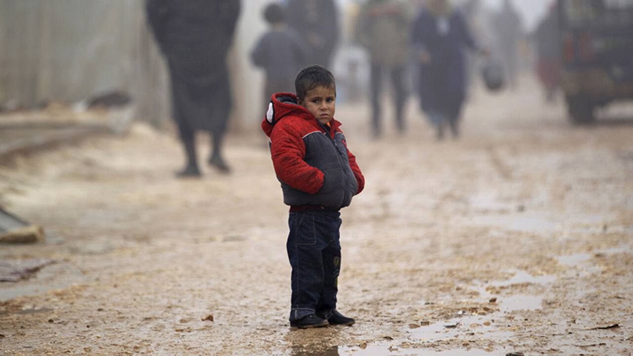 MIDEAST-CRISIS/SYRIA A boy stands outside tents housing internally displaced people, during the cold weather in Jerjnaz camp, in Idlib province, Syria, January 5, 2016. REUTERS/Khalil Ashawi - RTX21508