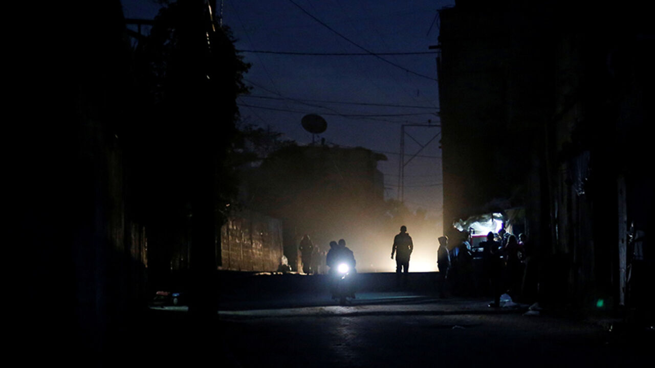 PALESTINIANS-GAZA/ELECTRICITY Palestinians ride a motorcycle during a power cut on a street in Beit Lahiya in the northern Gaza Strip January 11, 2017. Picture taken January 11, 2017. REUTERS/Mohammed Salem - RTX2YLZ2