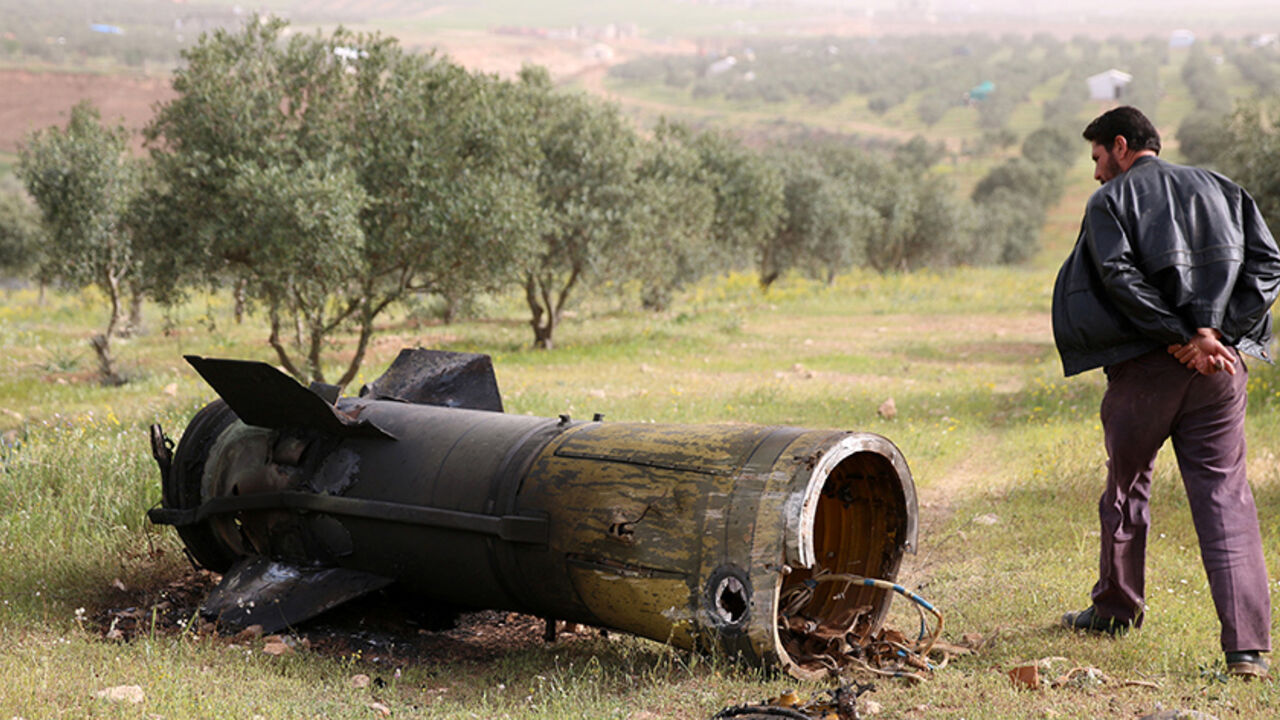 MIDEAST-CRISIS/SYRIA A man inspects a piece of a rocket that landed south of Daraa Al-Balad, Syria, April 5, 2017. REUTERS/Alaa Al-Faqir - RTX348K8